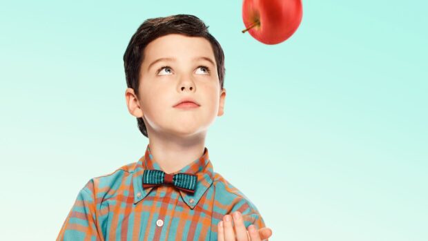 A young boy from Young Sheldon tv series looks up at a floating red apple against a blue background, HD Desktop Wallpaper