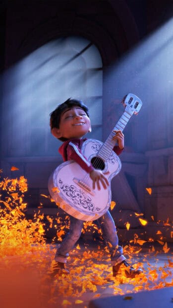 A young boy is joyfully playing guitar surrounded by glowing petals with Pixar Wallpapers, HD Mobile Wallpaper