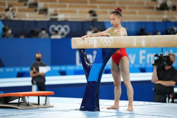 A young gymnast is preparing on the balance beam during a competition at the Tokyo 2020 Olympics, HD Desktop Wallpaper
