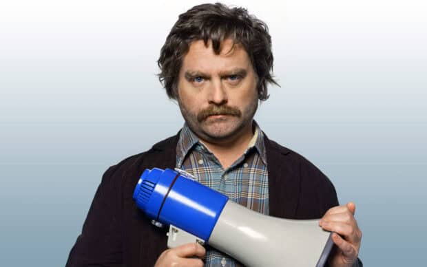 Zach Galifianakis holding a blue and white megaphone with a serious expression, 2K Desktop Wallpaper