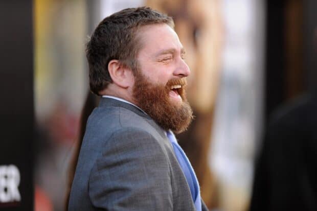 Zach Galifianakis is laughing joyfully at an event while wearing a suit and tie, HD Desktop Wallpaper