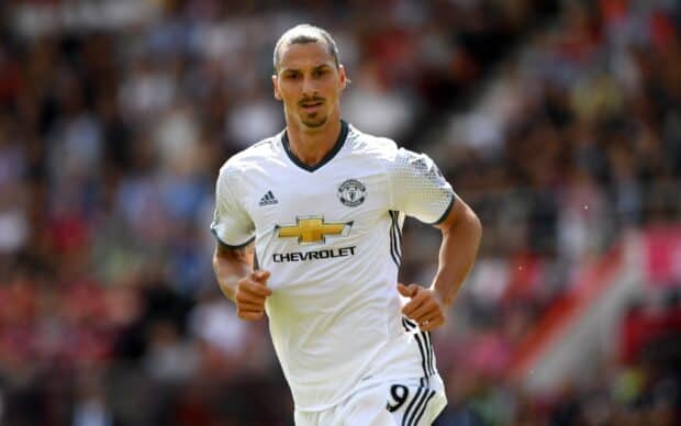 Zlatan Ibrahimovic is running on the field during a football match wearing a white Manchester United jersey, 2K Desktop Wallpaper