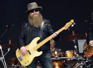 A Zz Top band member with a long beard playing a yellow bass guitar during a live performance, 2K Desktop Wallpaper