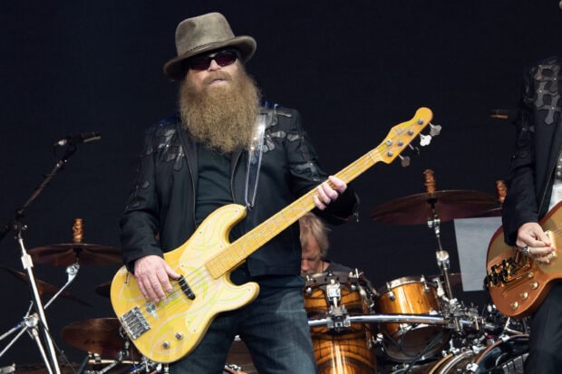 A Zz Top band member with a long beard playing a yellow bass guitar during a live performance, 2K Desktop Wallpaper