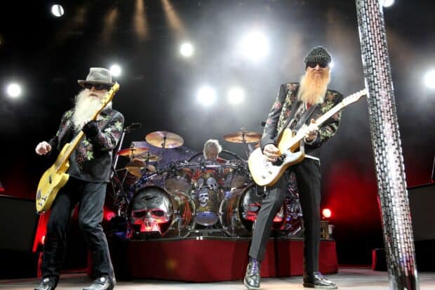 Zz Top playing guitars on stage with drummer in the background, 2K Desktop Wallpaper