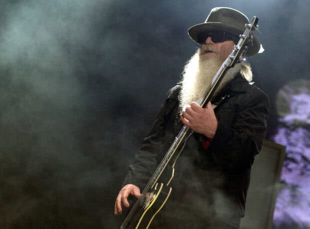 A Zz Top musician with a long beard is playing guitar during a performance with smoky effects, HD Desktop Wallpaper
