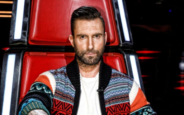 Adam Levine is sitting on a red chair wearing a colorful knitted sweater in this image, 2K Desktop Wallpaper