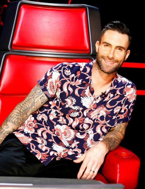 Adam Levine smiling while sitting on a red chair wearing a floral patterned shirt, 2K Desktop Wallpaper