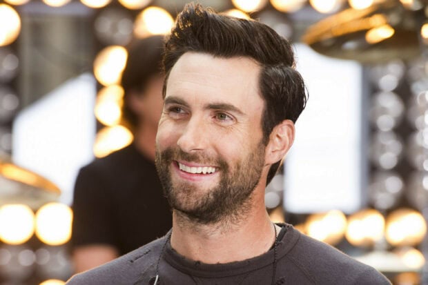 Adam Levine Wallpapers showing a happy expression with glowing lights behind him, HD Desktop Wallpaper