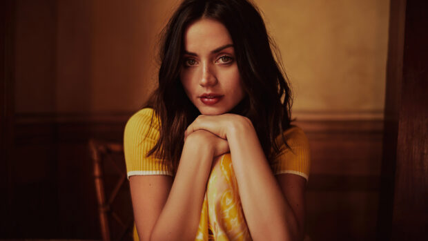 Ana De Armas is resting her chin on her hands with warm lighting, 4K Desktop Wallpaper