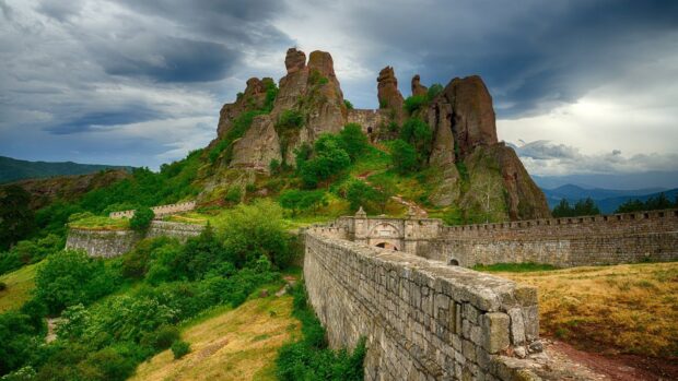 A stone fortress with rocky hills and lush greenery depicts Bulgaria wallpapers in a scenic view, HD Desktop Wallpaper