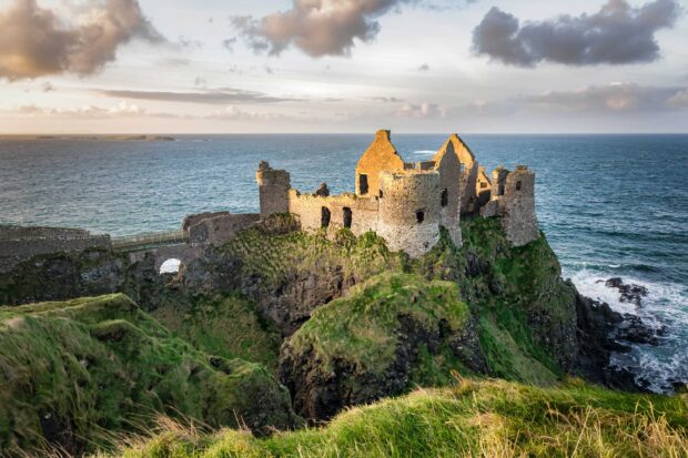 The ancient castle ruins sit on steep cliffs by the ocean in Northern Ireland Wallpapers, 2K Desktop Wallpaper