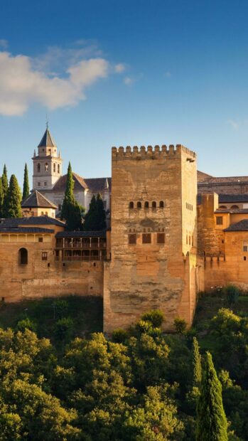 An ancient fortification stands surrounded by trees under a clear sky in Spain, 2K Phone Wallpaper
