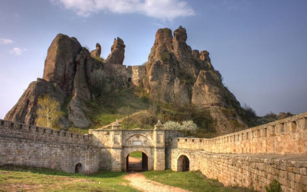 The ancient fortress built among rocky cliffs in Bulgaria reveals historical architecture, 2K Desktop Wallpaper