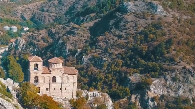 An ancient monastery stands on a rocky hill surrounded by forest in Bulgaria, HD Desktop Wallpaper