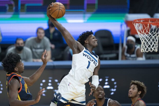 Anthony Edwards in Wolves uniform jumping to dunk a basketball during a game