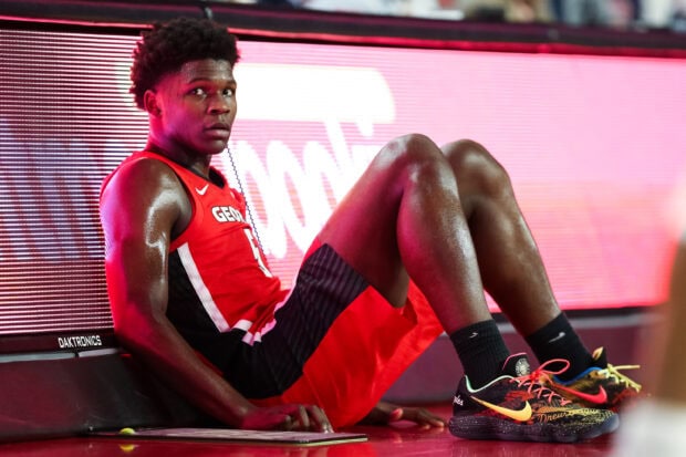 Anthony Edwards sitting on the court floor during a basketball game in a red Georgia uniform