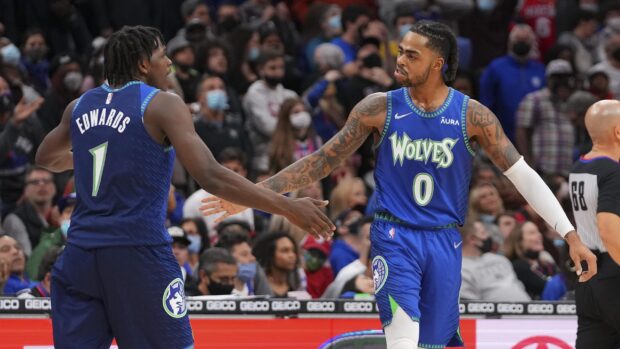 Anthony Edwards in a Minnesota Wolves basketball uniform celebrating with a teammate during a game