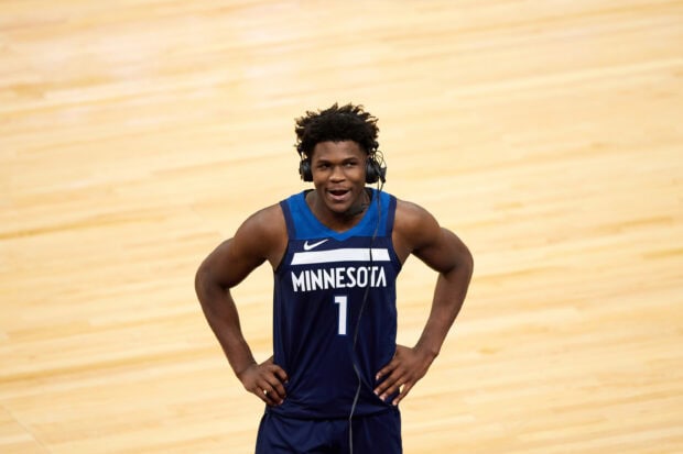 Anthony Edwards in Minnesota basketball jersey wearing a headset on the court