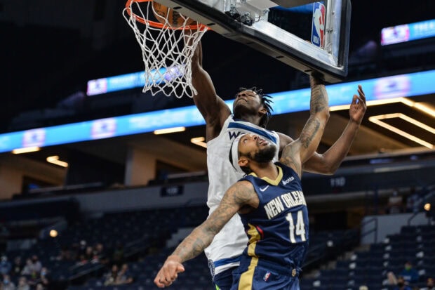 Anthony Edwards jumping to dunk the basketball in a game against the New Orleans player
