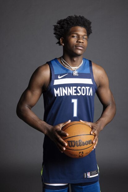 Anthony Edwards holding a basketball wearing Minnesota jersey in a studio setting