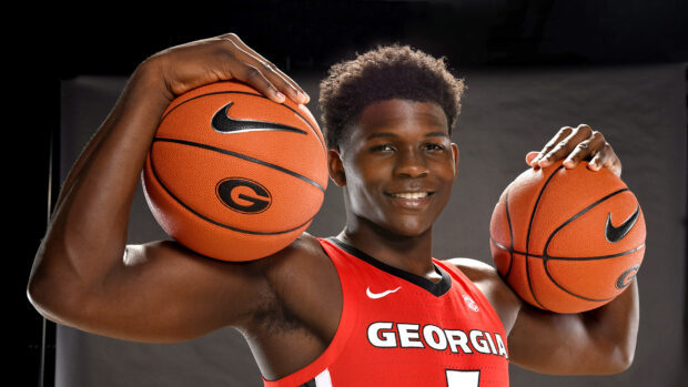 Anthony Edwards posing confidently with two basketballs wearing a Georgia jersey