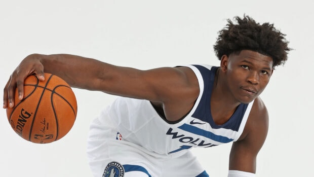 Anthony Edwards holding a basketball in a Wolves uniform in a dribbling pose