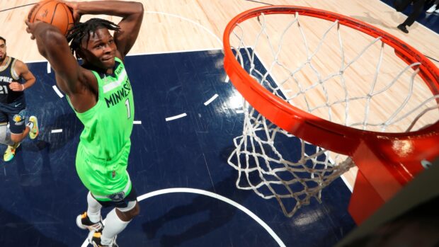 Anthony Edwards jumping to dunk during basketball game on court in Minnesota uniform