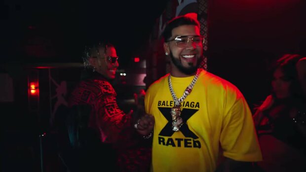Anuel Aa is wearing a yellow shirt and smiling at a lively party scene, HD Desktop Wallpaper