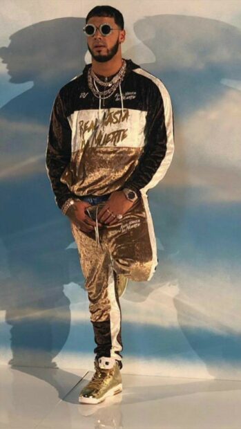 A man wearing gold and black tracksuit poses confidently in a studio setting with clear shadows, HD Phone Wallpaper