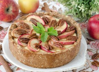 A pie with apple slices and pecans garnished with fresh mint leaves on a floral tablecloth, HD Desktop Wallpaper