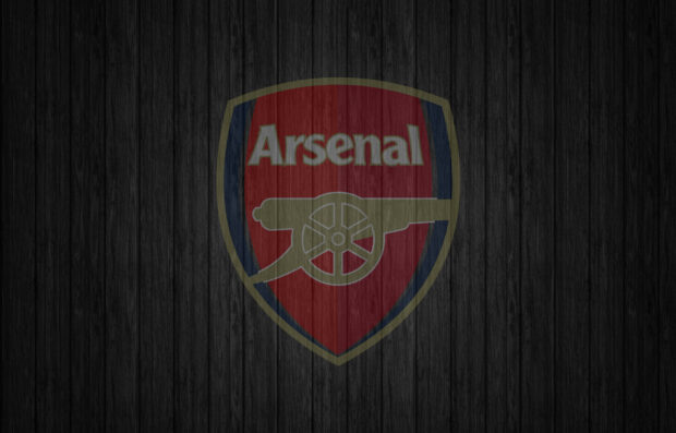 Arsenal Fc logo on a textured wooden background with dark tones