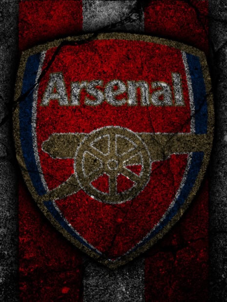 Arsenal fc emblem painted on a textured wall background with red and black stripes