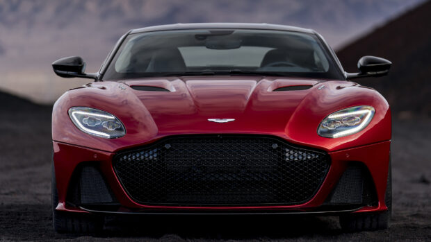 A sleek red Aston Martin car from the front view with detailed grille and headlights