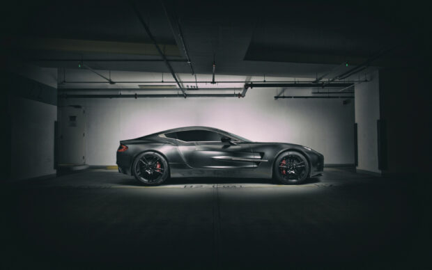 A sleek Aston Martin car parked in a dimly lit underground garage