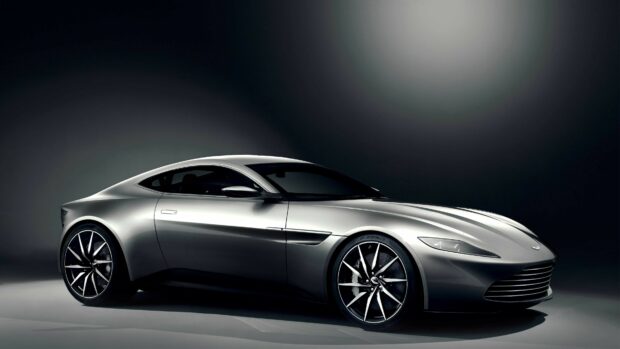 Sleek silver Aston Martin with modern design and large alloy wheels in dark studio setting