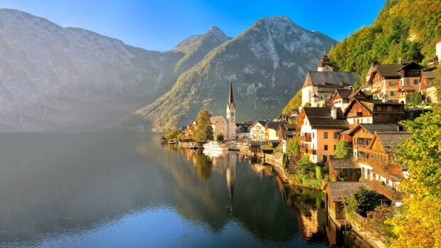 A peaceful Austrian village beside a serene lake with mountains in the background featuring Austria Wallpapers, 4K Desktop Wallpaper