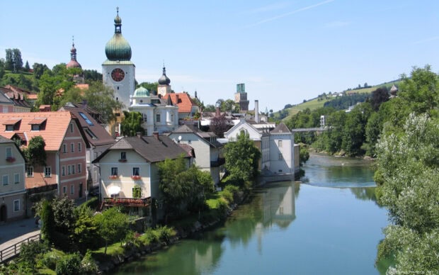 A peaceful town in Austria with historic buildings along a clear river, HD Desktop Wallpaper