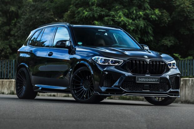 A sleek BMW X5 is parked on the street with green trees in the background, HD Desktop Wallpaper