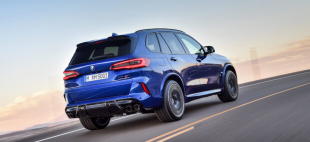 A blue BMW X5 drives smoothly on an open highway during sunset, HD Desktop Wallpaper
