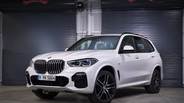 A white BMW X5 is parked inside a garage with closed shutters, 4K Desktop Wallpaper