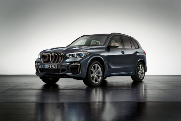 A black BMW X5 is parked on a reflective surface with a white background, HD Desktop Wallpaper