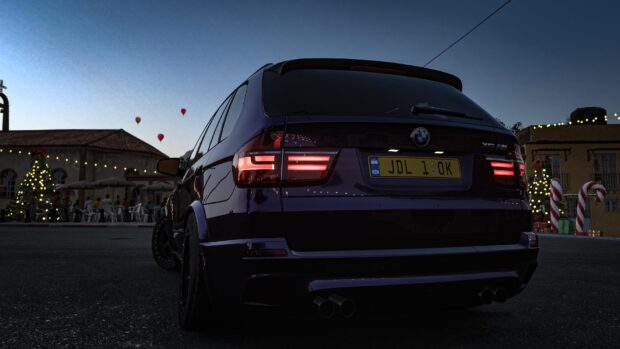 A BMW X5 is parked near festive decorations with a clear evening sky, 4K Desktop Wallpaper