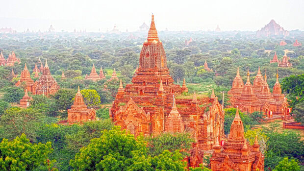 Ancient Bagan temples surrounded by lush greenery in a historic Myanmar landscape