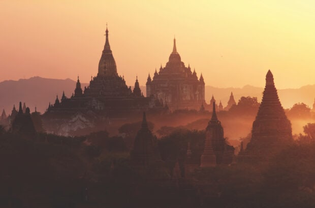 Ancient Bagan temples surrounded by mist during sunrise in Bagan