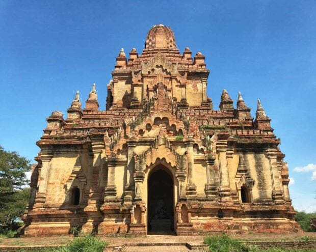 Ancient brick temple architecture in Bagan under clear blue sky