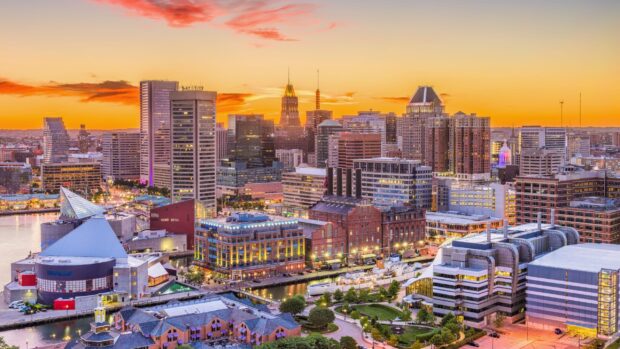 Baltimore skyline at sunset with vibrant orange sky and illuminated city buildings