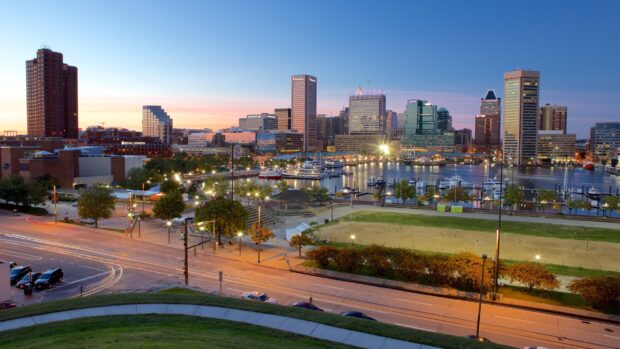 The Baltimore skyline with tall buildings and harbor at dusk in the cityscape view