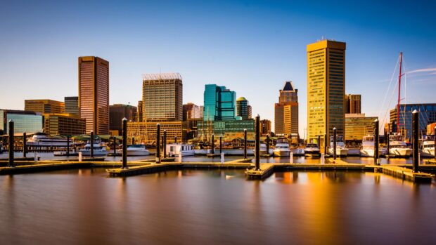 A high definition view of Baltimore skyline with boats docked at the harbor during sunset