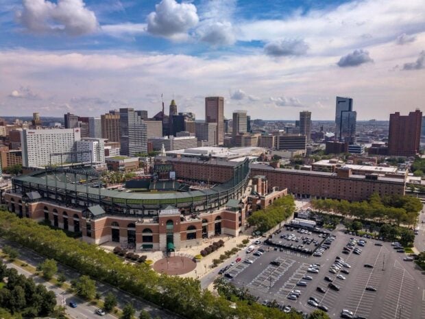 A high view of Baltimore skyline showing the baseball stadium and city buildings under a partly cloudy sky